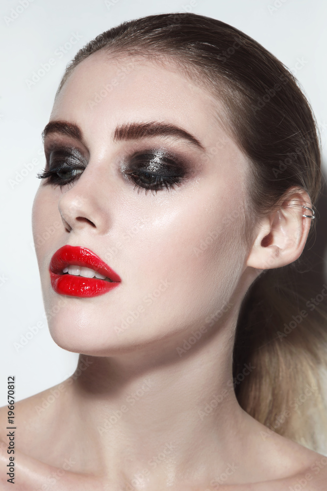 Young beautiful woman with red lipstick and wet smoky eye make-up