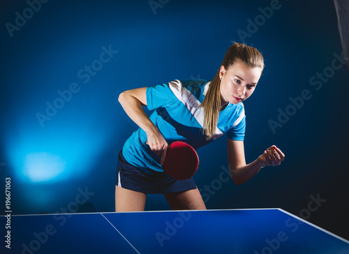 Portrait Of Young Woman Playing Tennis On Black Background with lights