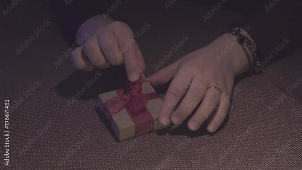 Paper box in his hands. Red bow on the box. Valentine's day. Romantic theme. The empty space in the frame. Design element. 4K video Paper box in his hands. Red bow on the box. Valentine's day. Romantic theme. The empty space in the frame. Design element. 4K video