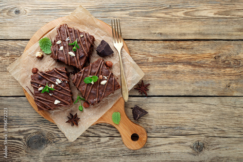 Chocolate brownie cake, dessert with nuts on wooden background.top view