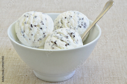 Stracciatella Eiscreme / Stracciatella Eis in einer weißen Schale auf beigem Hintergrund, Nahaufnahme, Makro, Format füllend