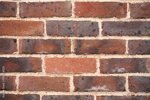 Closeup of dark-red, roasted brick wall for background.