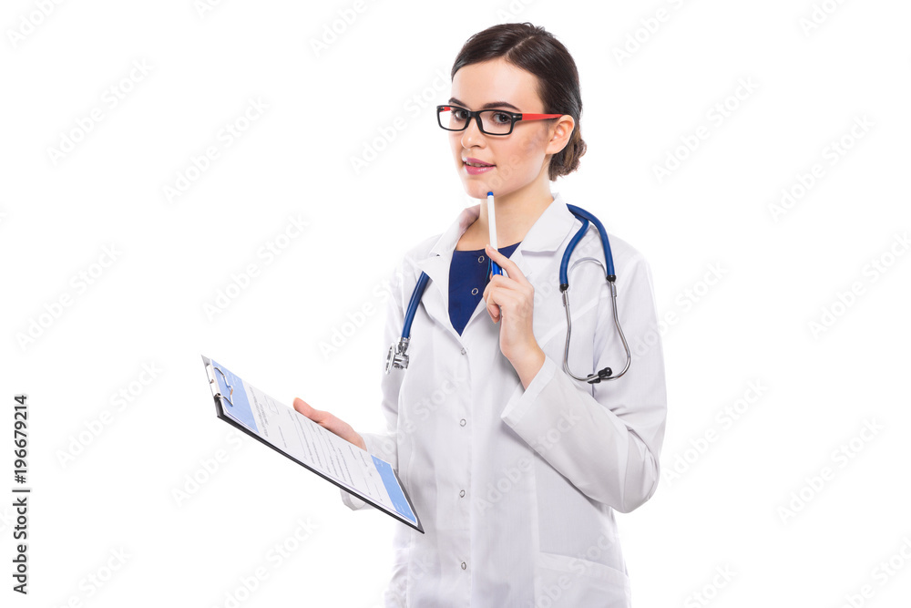 Young woman doctor with stethoscope holding clipboard and pen in her hands in white uniform on white background