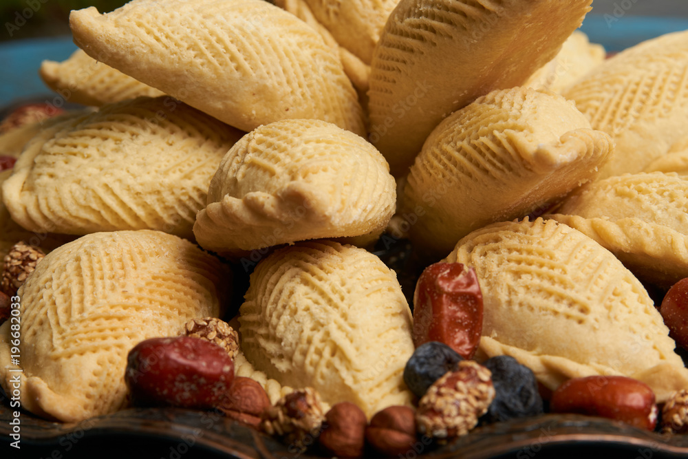 Shekerbura with nuts and honey on wooden table background. Delicious dessert for Azerbaijan national holiday Novruz tray Shekerbura with nuts and honey on wooden table background. Delicious dessert for Azerbaijan national holiday Novruz tray