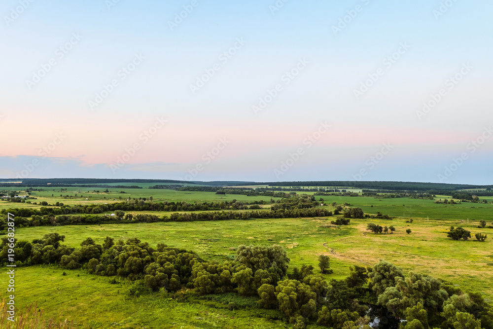 View of green forest-steppe plain. Flatland valley in evening time. Belgorod region, Russia.