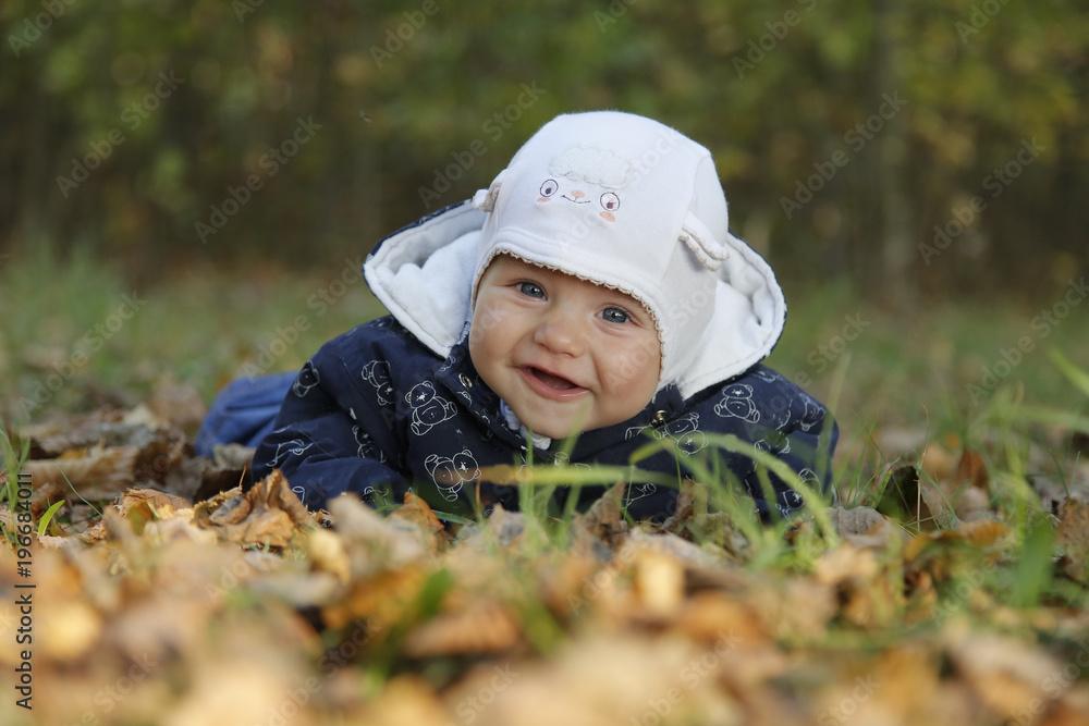 Beautiful baby smiling lying on autumn leaves Beautiful baby smiling lying on autumn leaves