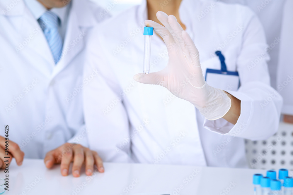 Team of scientific researchers in laboratory studying substances or blood sample. New vaccine for pharmacology industry is s almost ready. Medicine and science concept Team of scientific researchers in laboratory studying substances or blood sample. New vaccine for pharmacology industry is s almost ready. Medicine and science concept