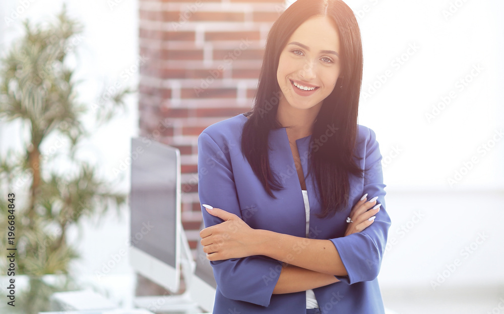 Attractive young businesswoman standing near desk in the office Attractive young businesswoman standing near desk in the office
