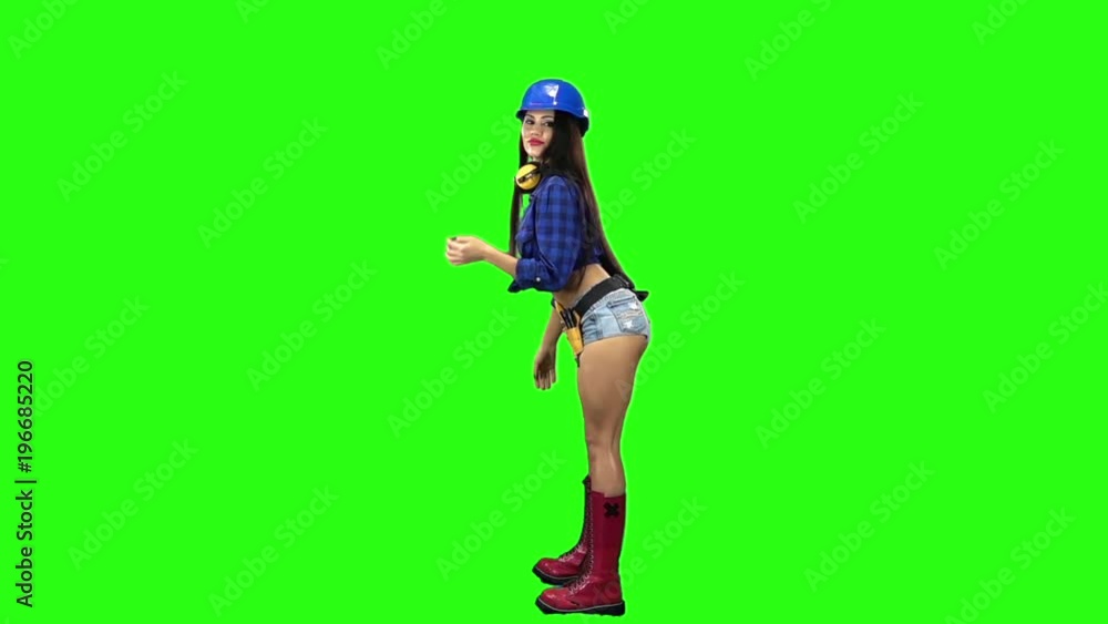 Side view of girl wearing helmet and shorts erotically dancing on green background. Slow motion Side view of girl wearing helmet and shorts erotically dancing on green background. Slow motion