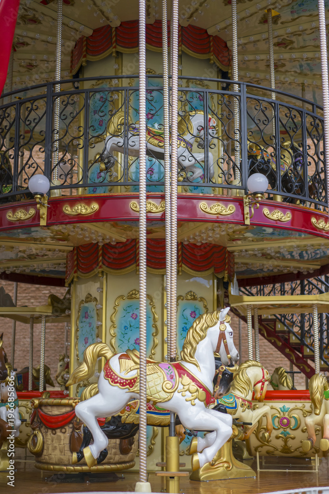 Circus, merry-go-round, beautiful game for children with colorful horses and fun in an outdoor park