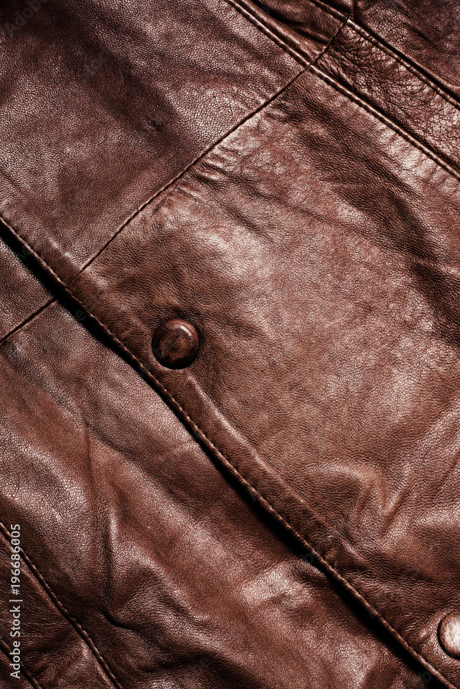Leather texture close-up with a button. Part of a leather jacket. Leather texture close-up with a button. Part of a leather jacket.