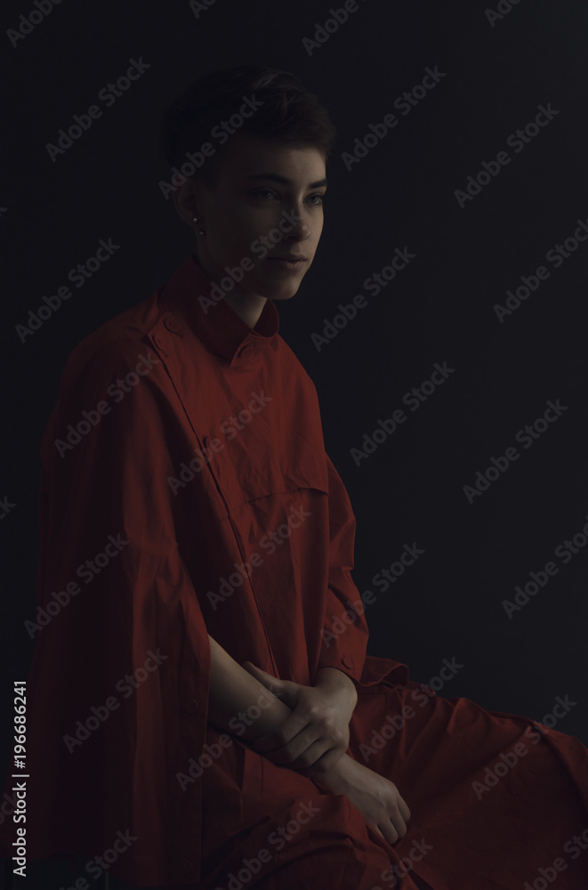 Dark/calm portrait study of young woman in red coat. Dark/calm portrait study of young woman in red coat.