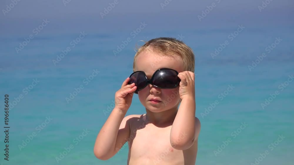 Funny boy try to arrange sunglasses, annoyed to fail, beautiful turquoise sea 4K Funny boy try to arrange sunglasses, annoyed to fail, beautiful turquoise sea 4K