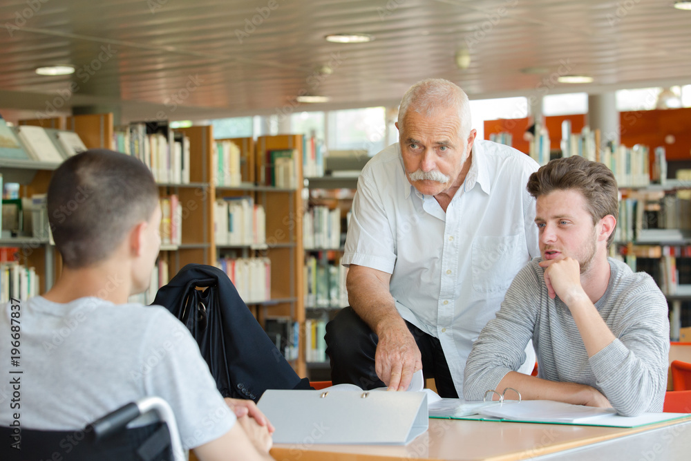 experienced teacher giving extra lesson in library experienced teacher giving extra lesson in library