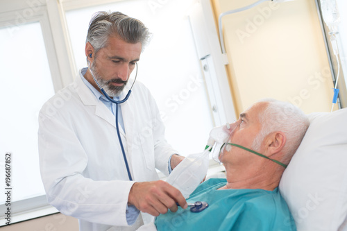 doctor checking on senior patient heart rate