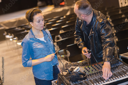 male and female sound engineers setting up before the gig photo