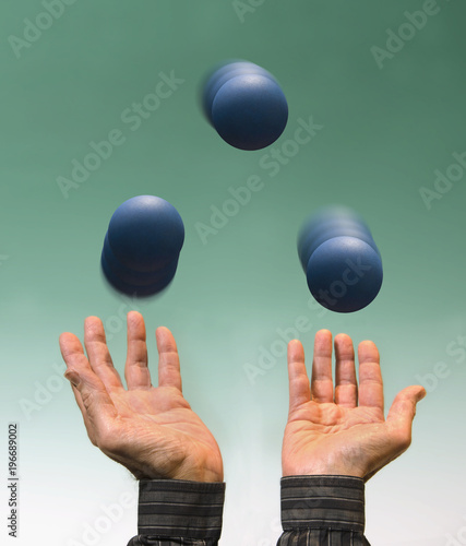 man's hands juggling three blue balls on limbo background
