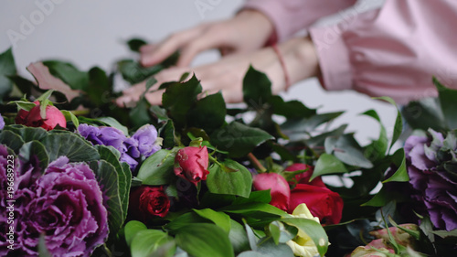 Florist puts beautiful roses for the arrangement of a modern bouquet