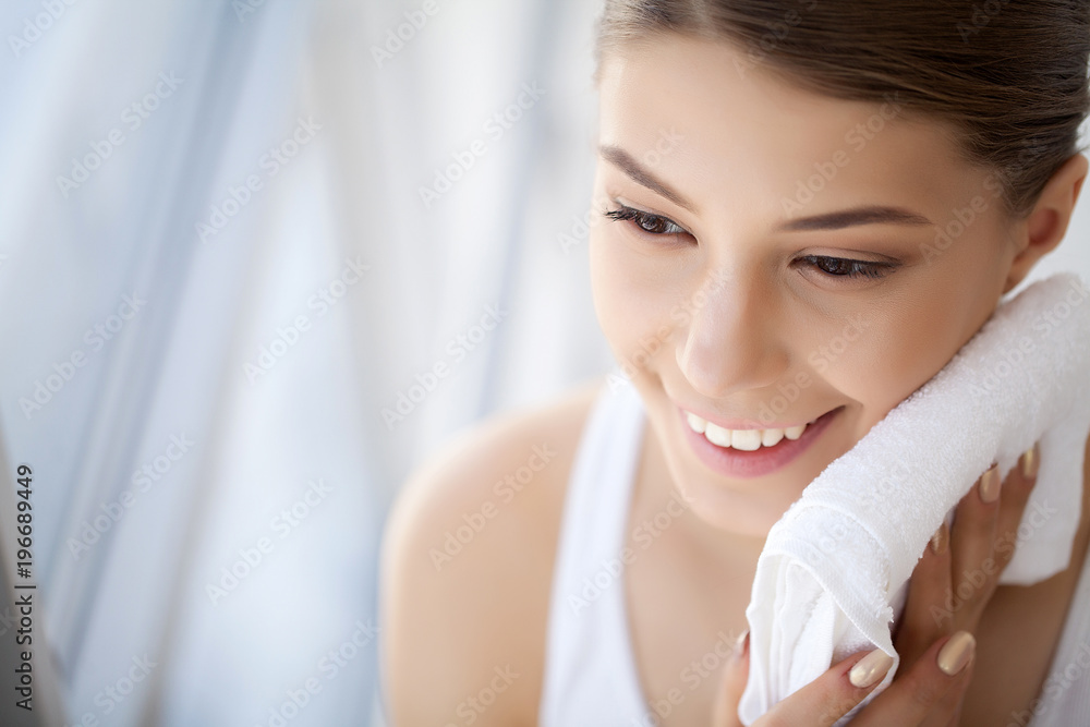 Cleaning Face Skin. Closeup Portrait Of Beautiful Happy Smiling Girl Holding Clean White Towel Near Facial Skin After Washing Face. High Resolution Cleaning Face Skin. Closeup Portrait Of Beautiful Happy Smiling Girl Holding Clean White Towel Near Facial Skin After Washing Face. High Resolution