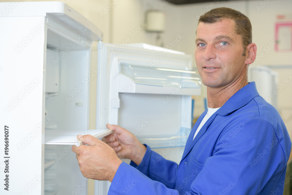 Repairman holding tray of refridgerator Repairman holding tray of refridgerator