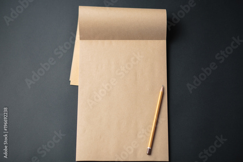 Kraft notebook with pencil on black background, craft note pad © alexxndr