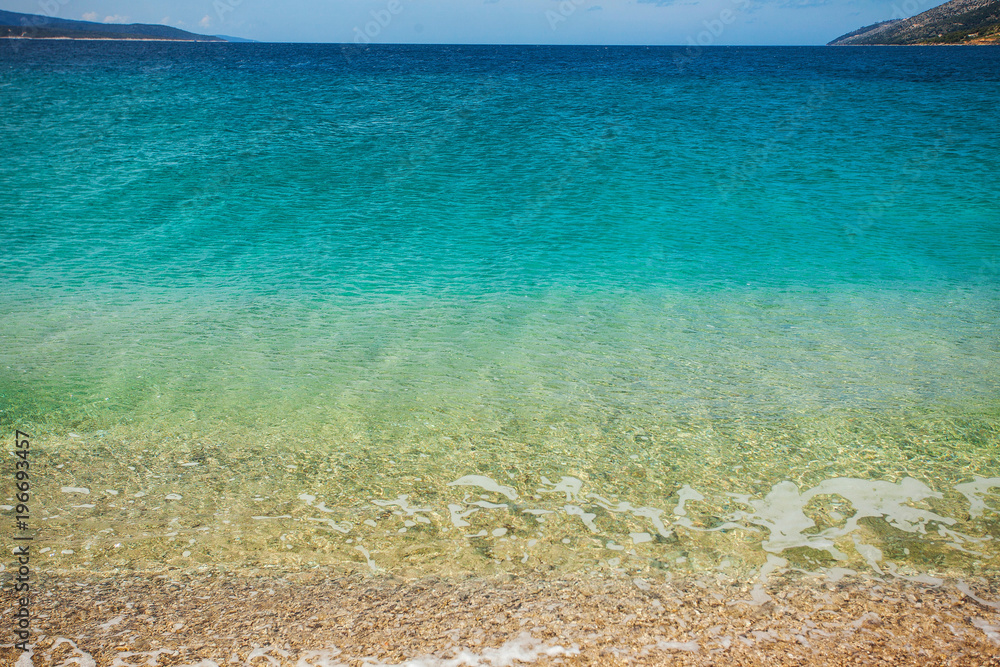 Sea water clean and transparent with gradient of blue, turquoise and gold colors