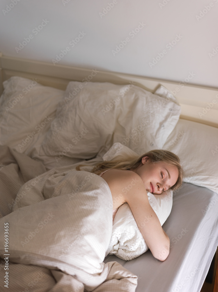 Young woman sleeping in bed in morning Young woman sleeping in bed in morning