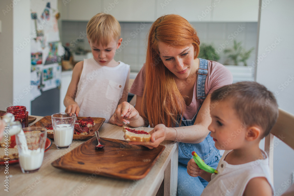 Woman and two sons having breakfast at home Woman and two sons having breakfast at home