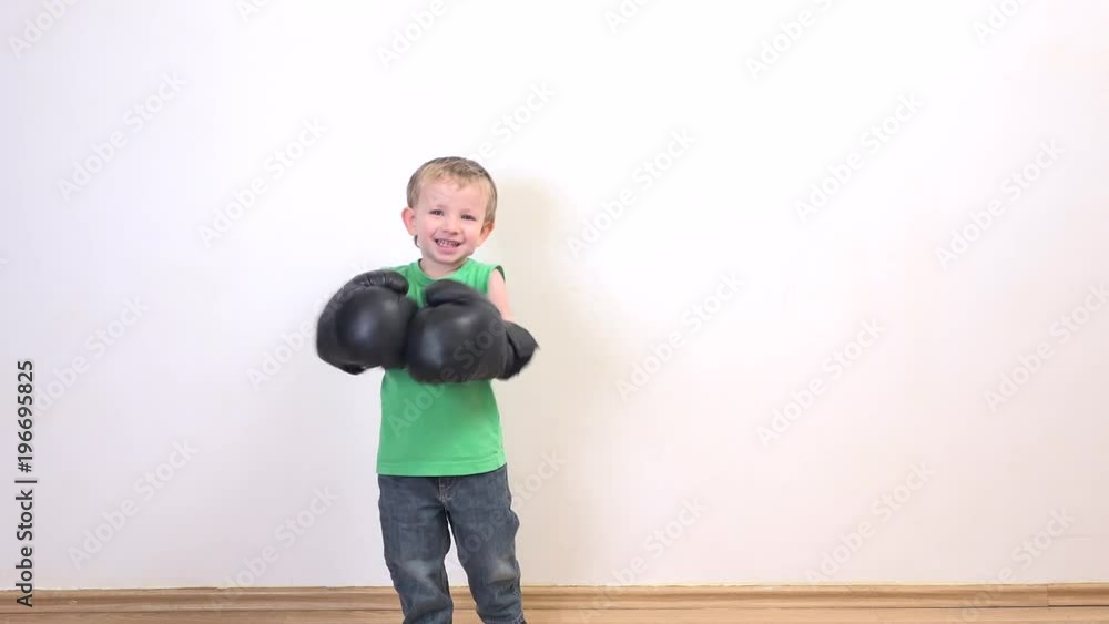 Funny child playing with box gloves, little fighter with big gloves, smiling Funny child playing with box gloves, little fighter with big gloves, smiling
