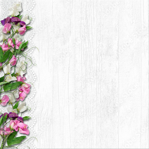 Border of beautiful spring flowers on a white wooden background