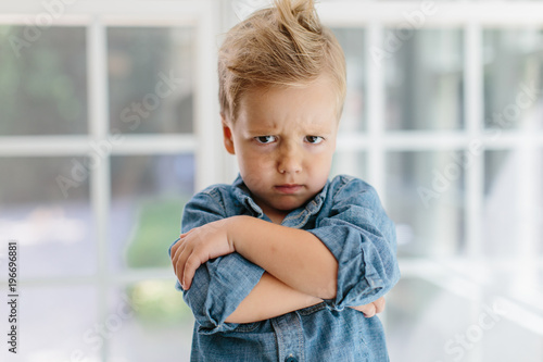 Young boy with wild hair looking defiant photo