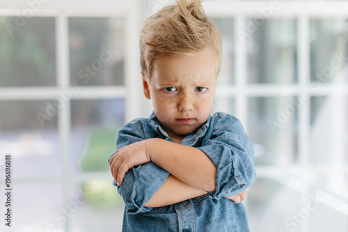Young boy with wild hair looking defiant