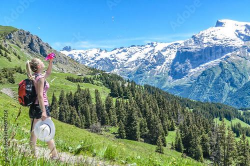 The girl watered herself with water from a bottle on the background of the Alpine landscape