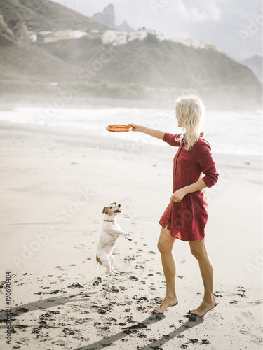 Woman playing with frisbee and dog photo