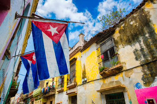 Cuban flags and colorful decaying buildings in Old Havana © kmiragaya