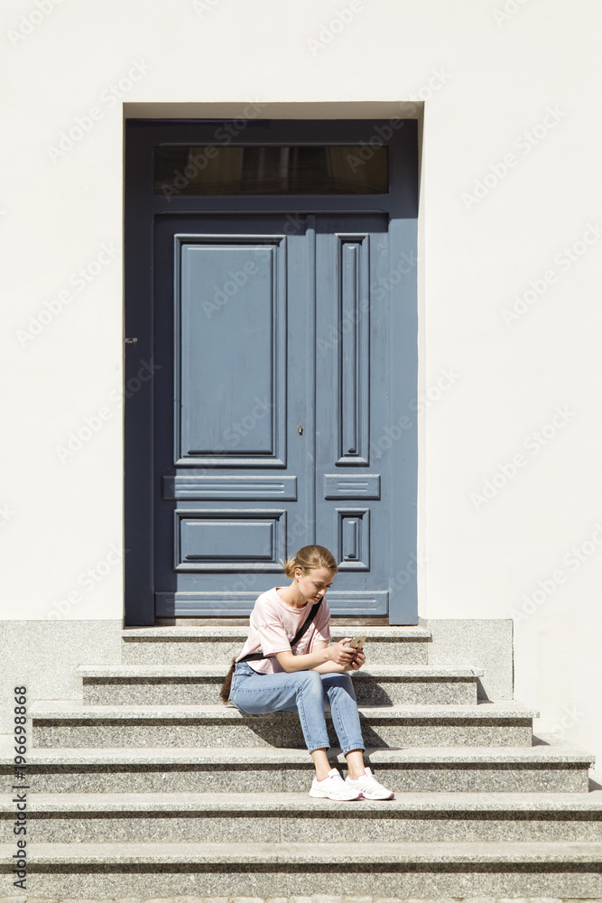 Woman browsing phone on stairs Woman browsing phone on stairs