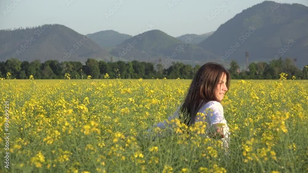 Young woman in rape blossom field enjoy to touch plants Young woman in rape blossom field enjoy to touch plants