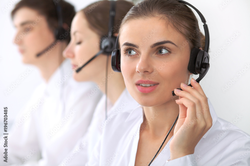 Call center. Focus on beautiful woman in headset Call center. Focus on beautiful woman in headset