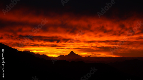 Sky on fire with mordor like volcano at sunset in Nahuel Huapi National Park, Argentina. photo