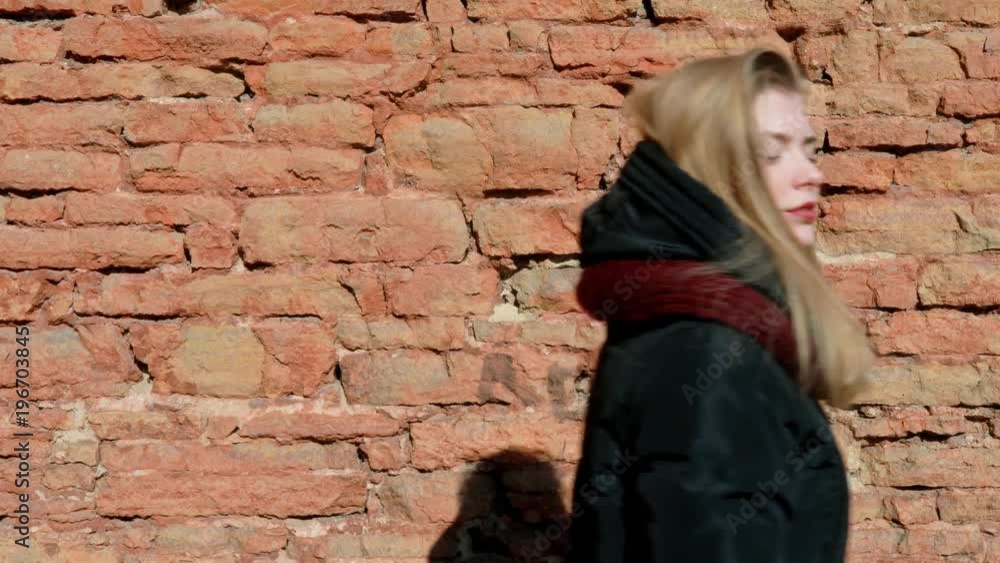Beautiful happy spring girl in the sun, hands showing no, stone texture of ancient masonry. Beautiful happy spring girl in the sun, hands showing no, stone texture of ancient masonry.