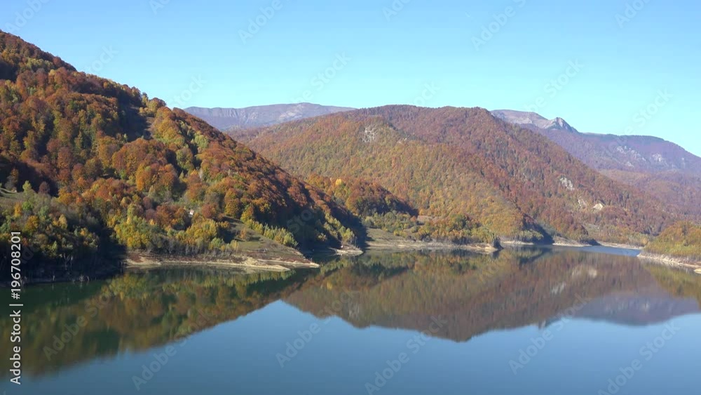 Autumn forest and blue serene sky reflected in tranquil lake, idyllic landscape Autumn forest and blue serene sky reflected in tranquil lake, idyllic landscape