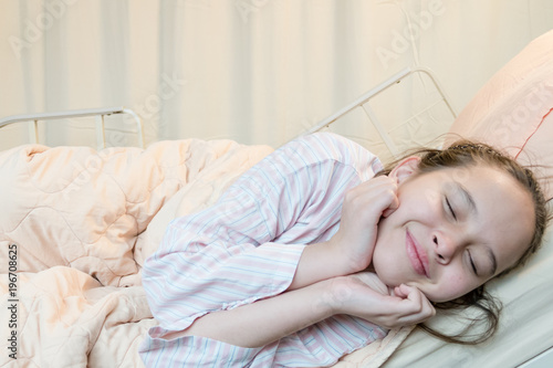 Cheerful mixed race tween girl in hospital bed