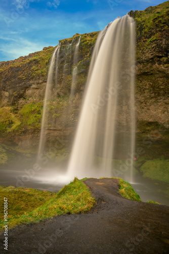 Seljalandsfoss : A  high beautiful waterfall in Iceland with clear blue sky and green grass on foreground., Iceland