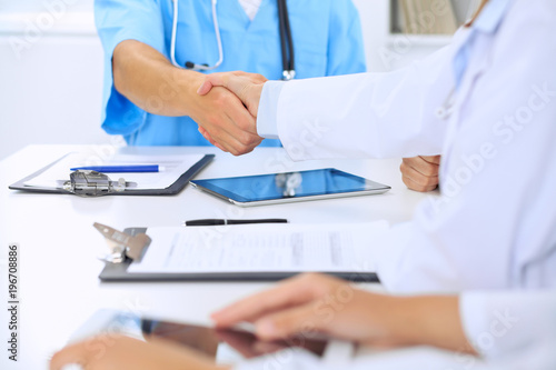 Doctors shaking hands to each other finishing up medical meeting