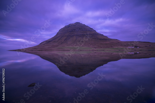 Long Exposure photography of kirkjufell Mountain with a lake in foreground and purple cloudy sky