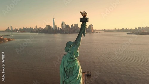 Statue of Liberty at beautiful sunset - aerial circling toward Manhattan skyline in New York City NYC in 4K and 1080 HD photo