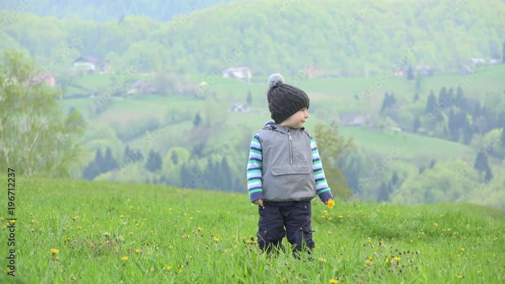 Lovely boy looking in light green grass, amazing spring mountain village view 4K Lovely boy looking in light green grass, amazing spring mountain village view 4K