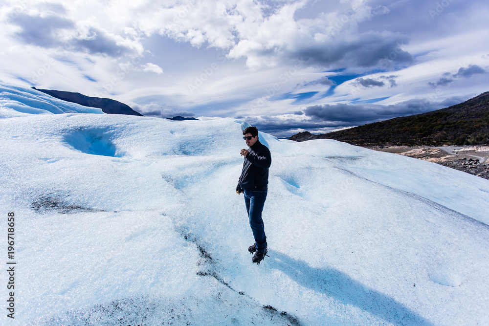 Man standing drinking whiskey on Glacier, black clothing, smilin Man standing drinking whiskey on Glacier, black clothing, smilin