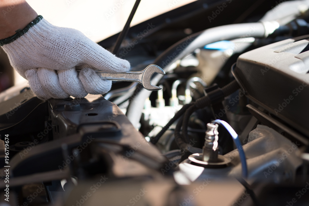 Mechanic repairing a car in garage Auto repair car engine, close u Mechanic repairing a car in garage Auto repair car engine, close u