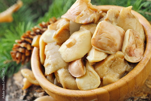 Pickled mushrooms in a wooden bowl